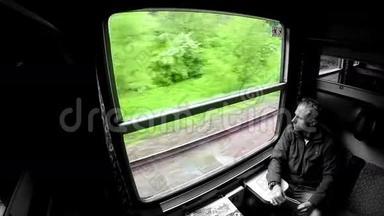 商务旅行者在火车旅行时透过窗户看。